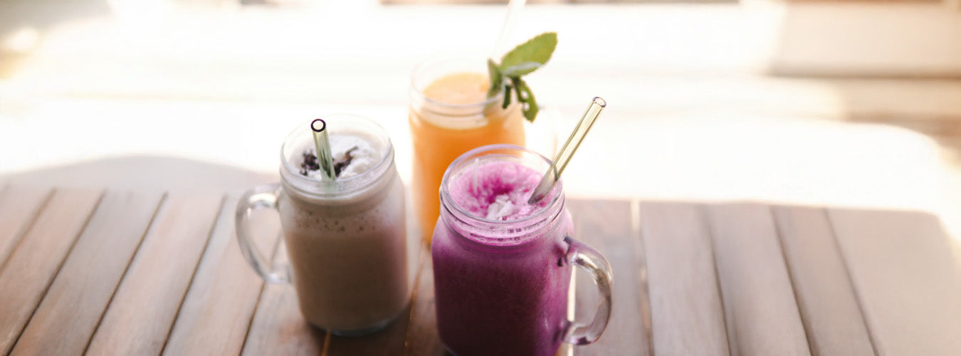 Drei bunte Frühlings-Smoothie im Glas auf einem Holztisch