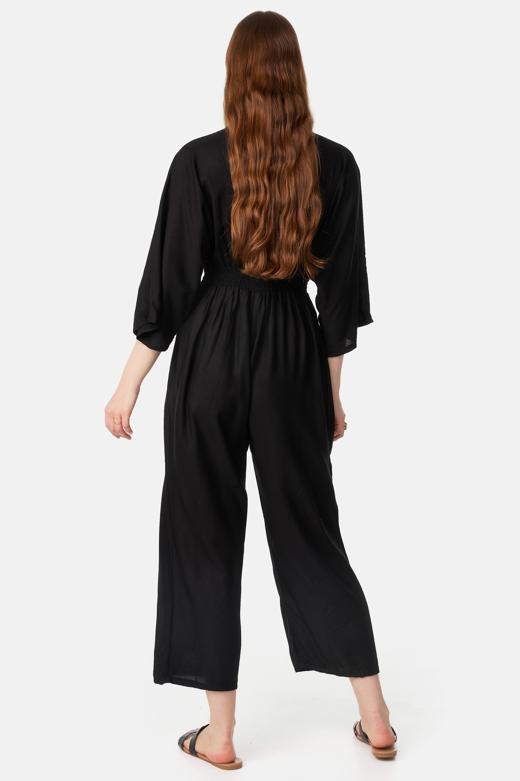 Frau in Jumper mit 3/4 Ärmeln und 7/8 Beinen von hinten