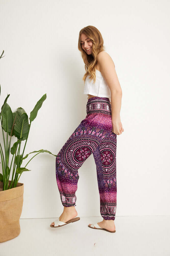 Seitenansicht einer Frau, die die gemusterte Haremshose in violetten Farbtönen trägt
