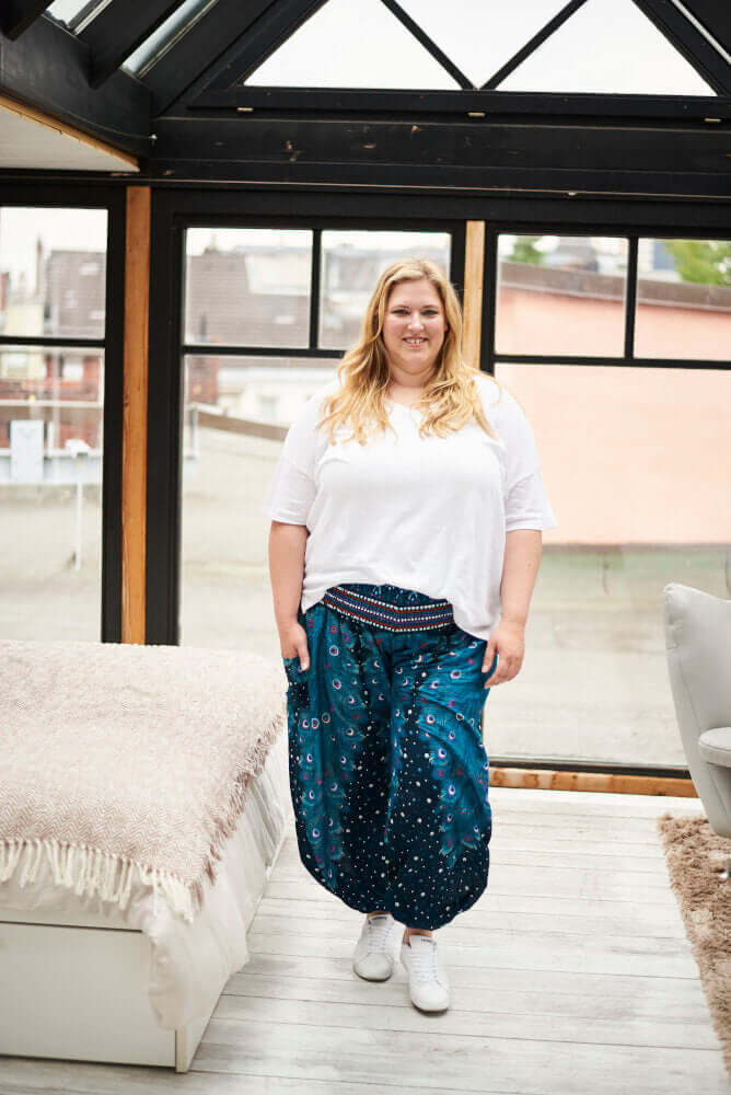 Frau in blau gemusterter Haremshose Grünes Pfauenauge Plus Size von vorne