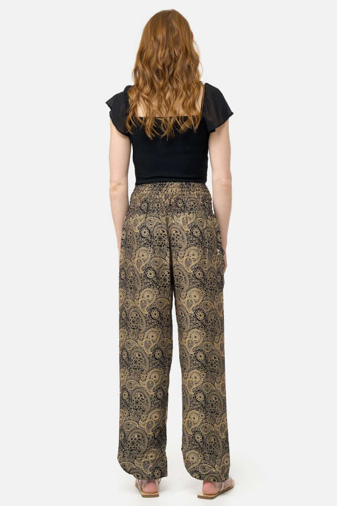 Frau in langer schwarz-goldener Haremshose Goldene Ornamente von hinten