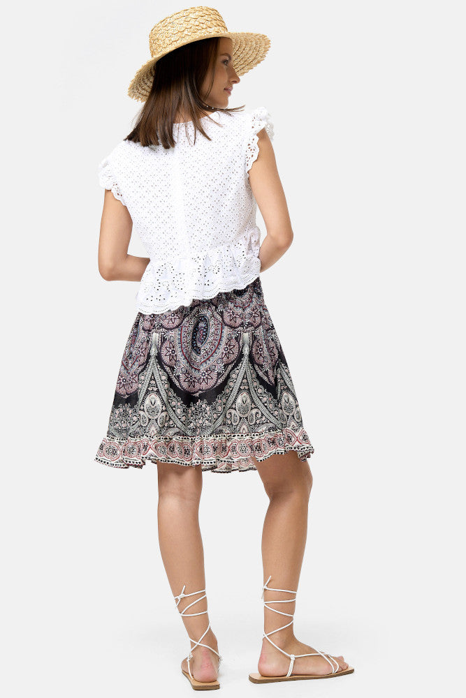 Frau in kurzem Rock Arktischer Blütentempel mit schwarz-rosa Muster von hinten