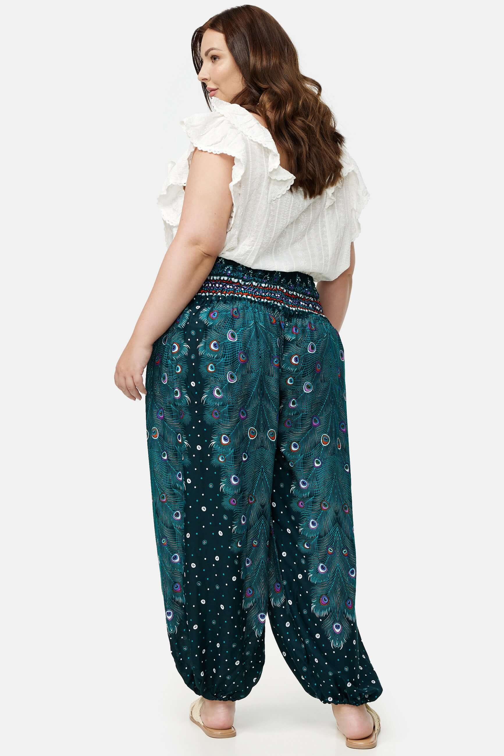 Frau in blau gemusterter Haremshose Grünes Pfauenauge Plus Size von hinten