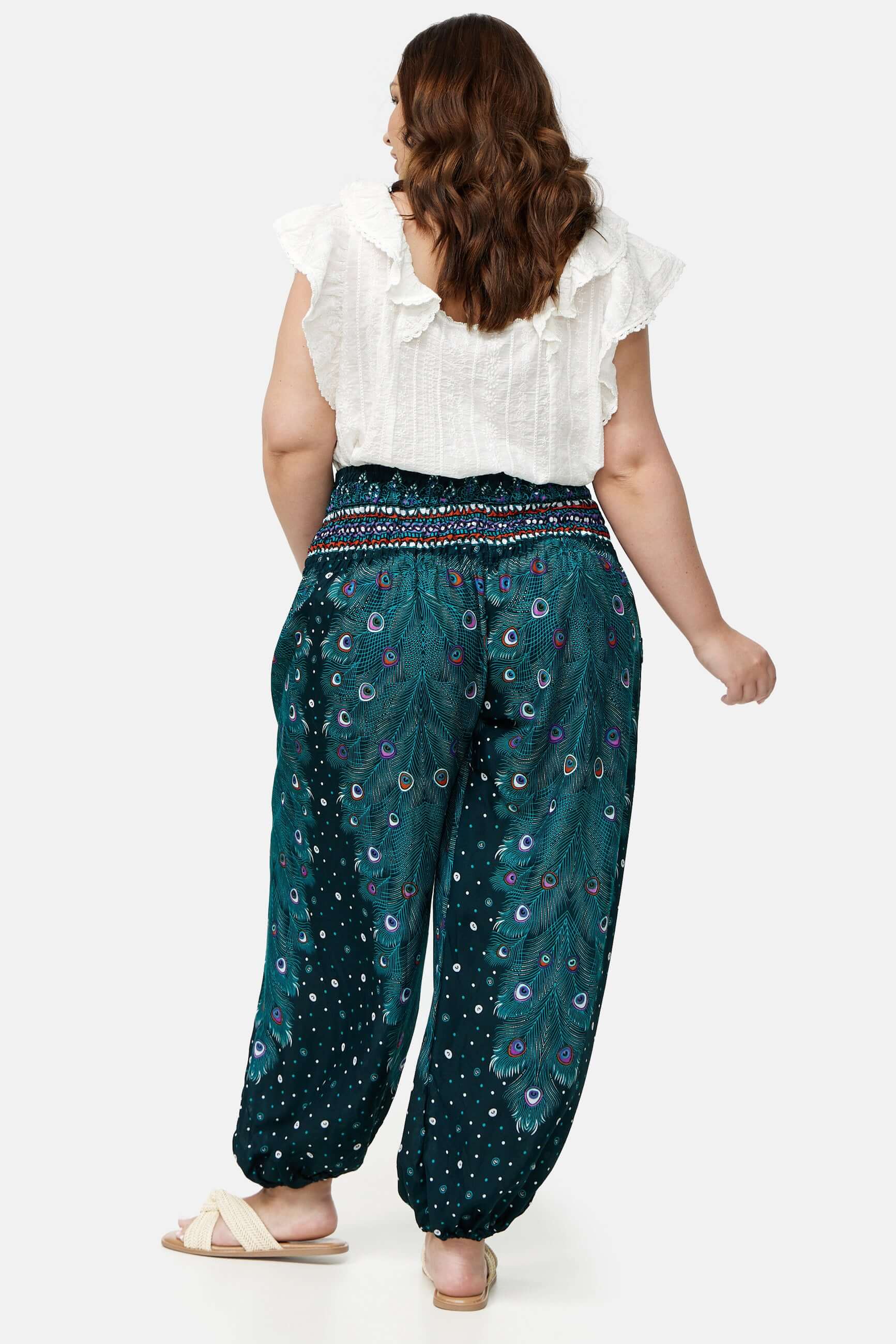 Frau in blau gemusterter Haremshose Grünes Pfauenauge Plus Size von hinten