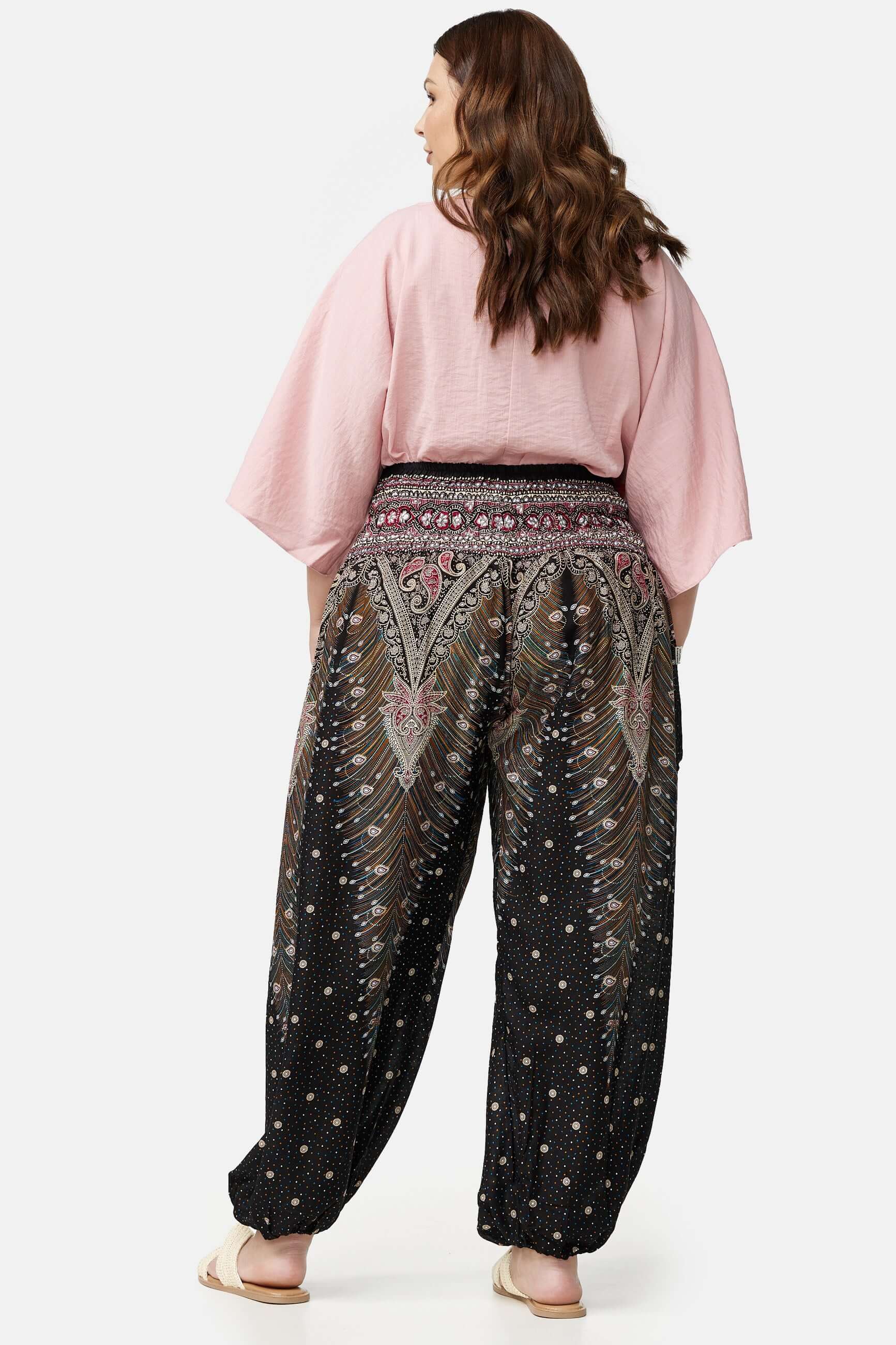 Frau in schwarz-bunter Haremshose Orientalisches Universum Plus Size von hinten