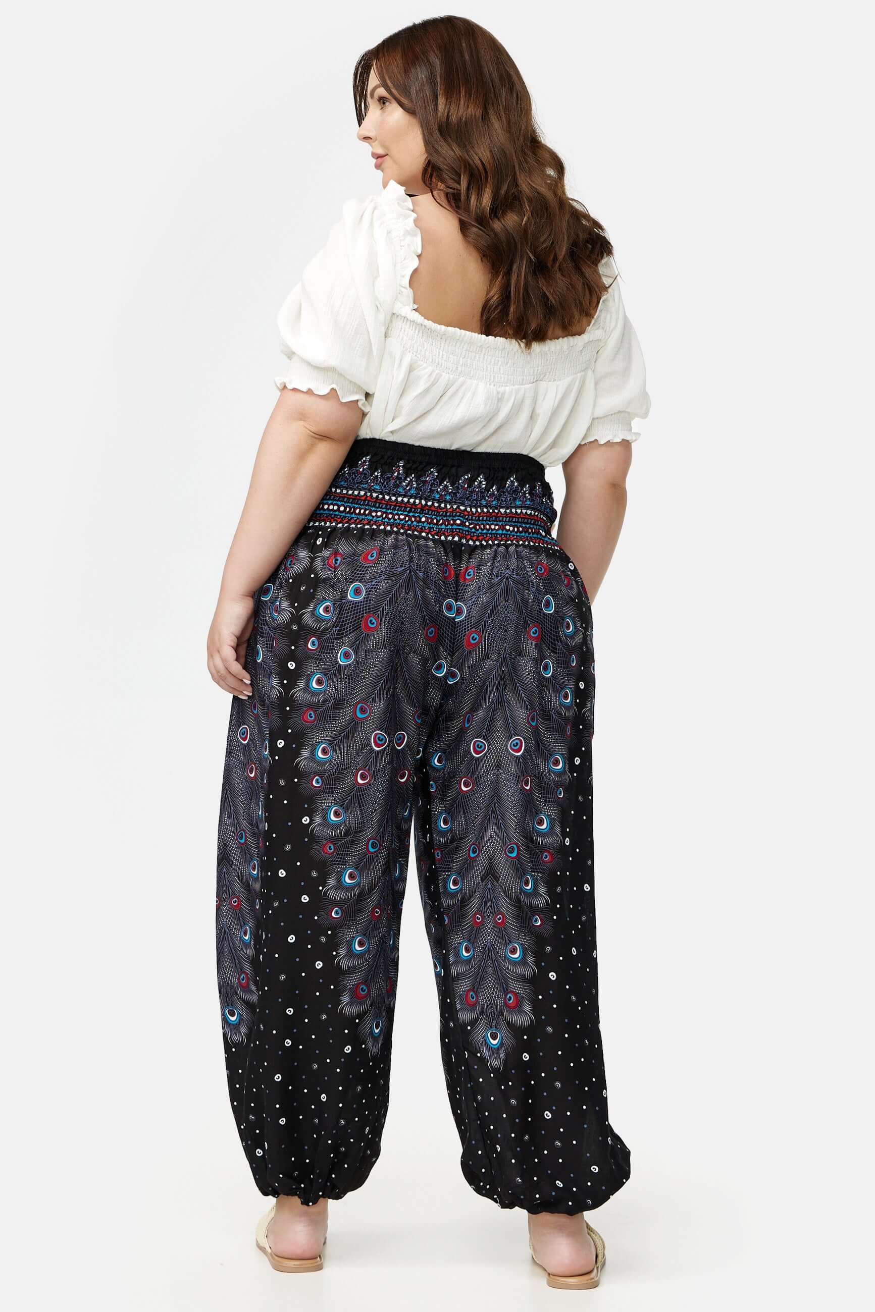 Frau in schwarz gemusterter Haremshose Schwarzer Pfauenauge Plus Size von hinten