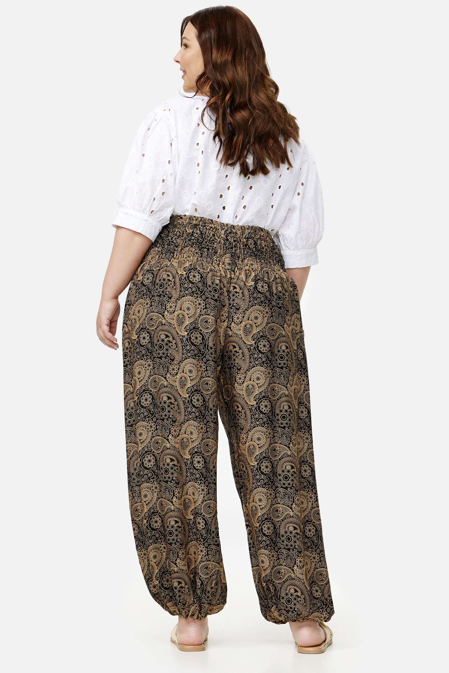 Frau in schwarz-goldener Haremshose Goldene Ornamente Plus Size von hinten