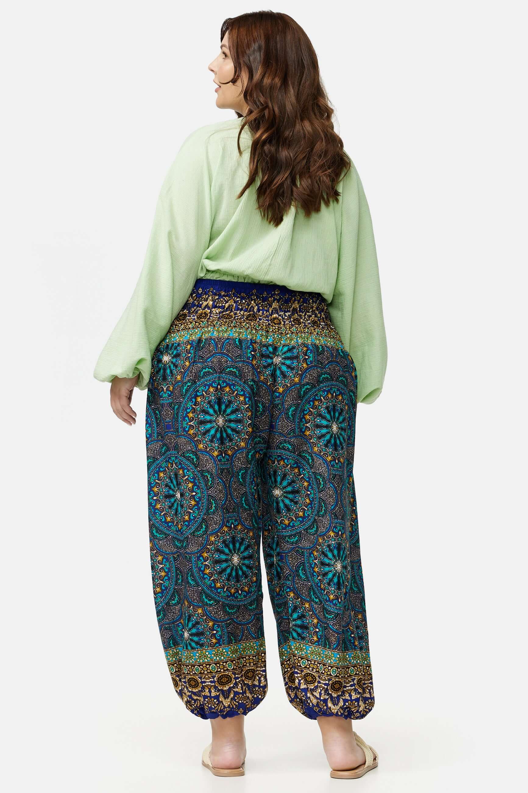Frau in blau gemusterter Haremshose Plus Size von hinten