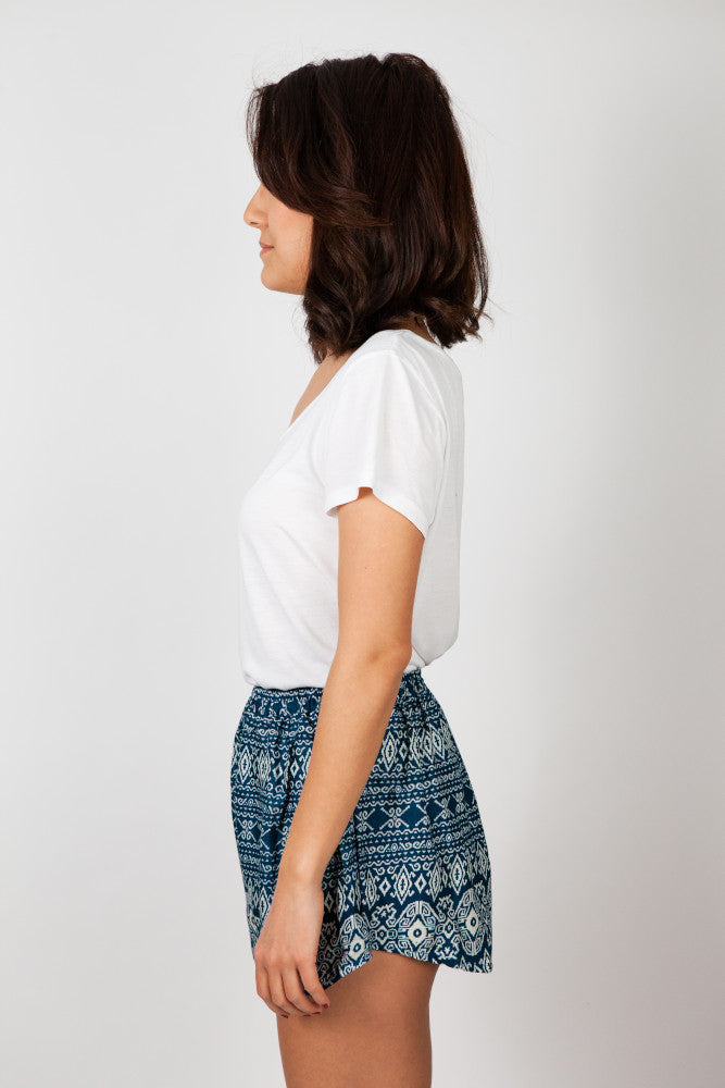 Frau in grün gemusterter Wald Labyrinth Shorts von der Seite
