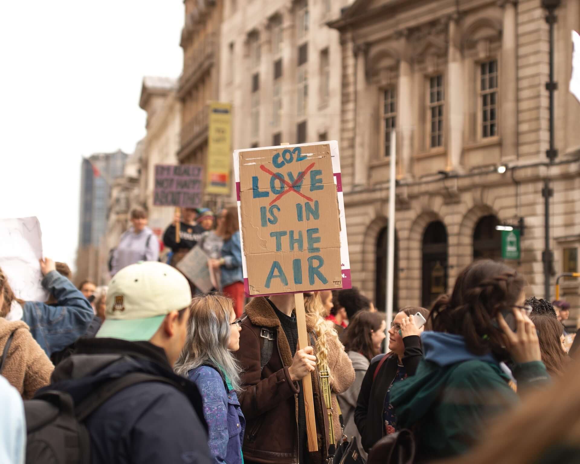 plakat auf einer demonstration ruft zum co2 sparen auf