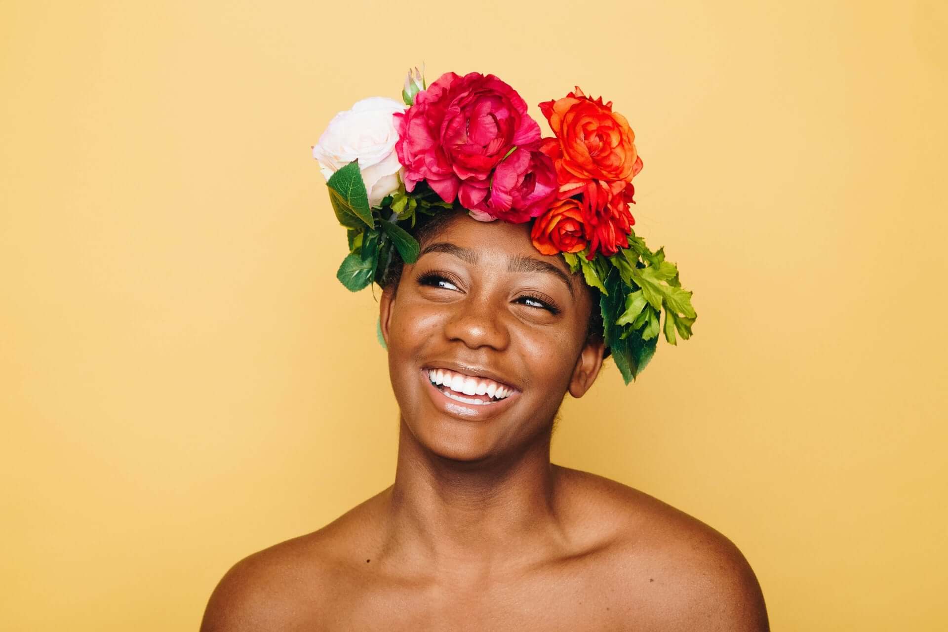 Frau mit Blumenkrone lächelt: Positives Mindset