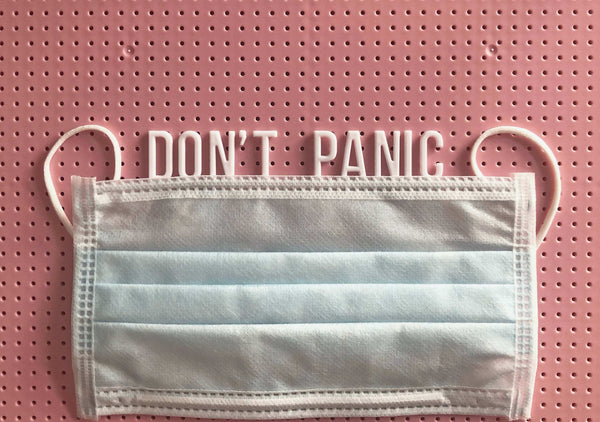 Corona Krise Angst: Mundschutz und Schrift "Don't Panic" 
