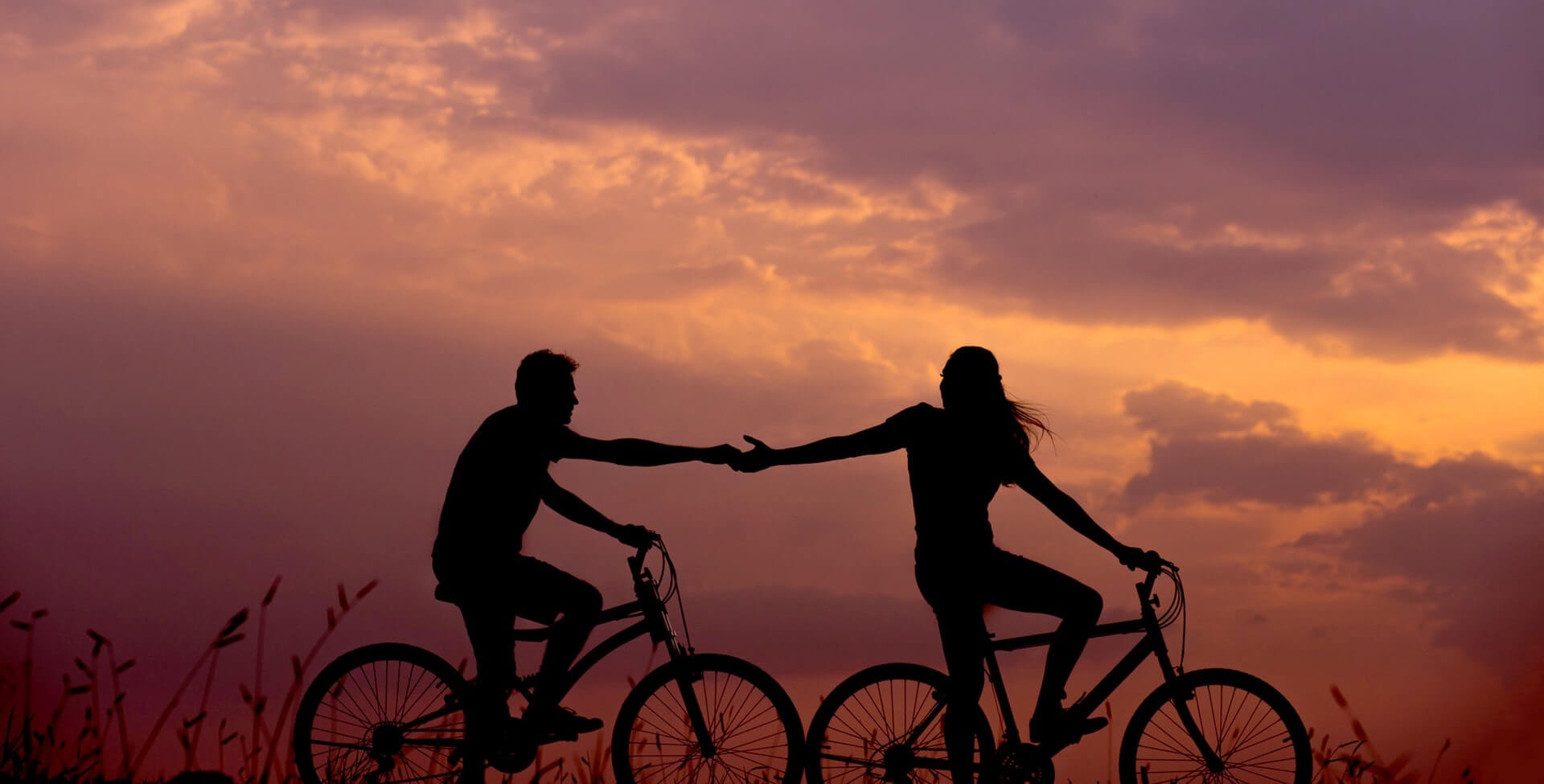 Beziehung stärken: Paar fährt zusammen Fahrrad bei Sonnenuntergang