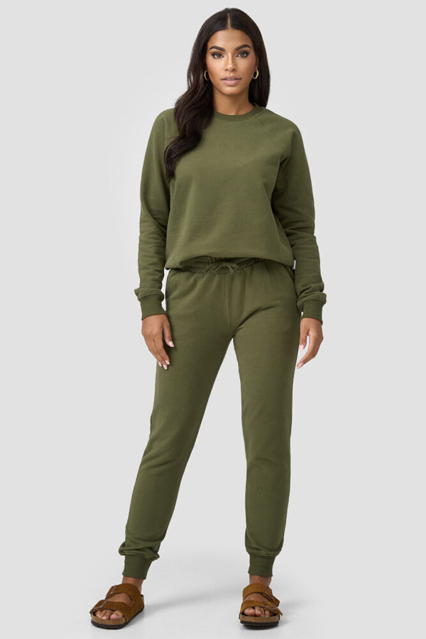 Frau kombiniert olivefarbene Sweatpants mit gleichfarbigen Sweater