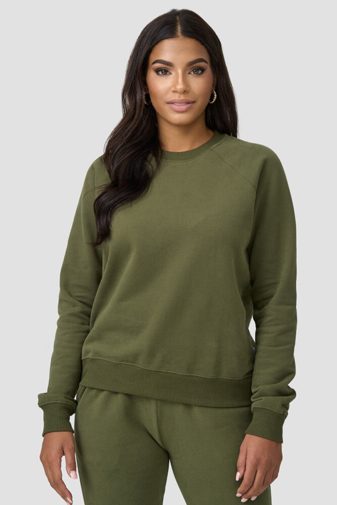 Frau trägt den olivfarbigen Sweater