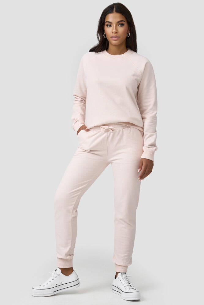 Frau kombiniert rosafarbene Sweatpants mit gleichfarbigen Sweater