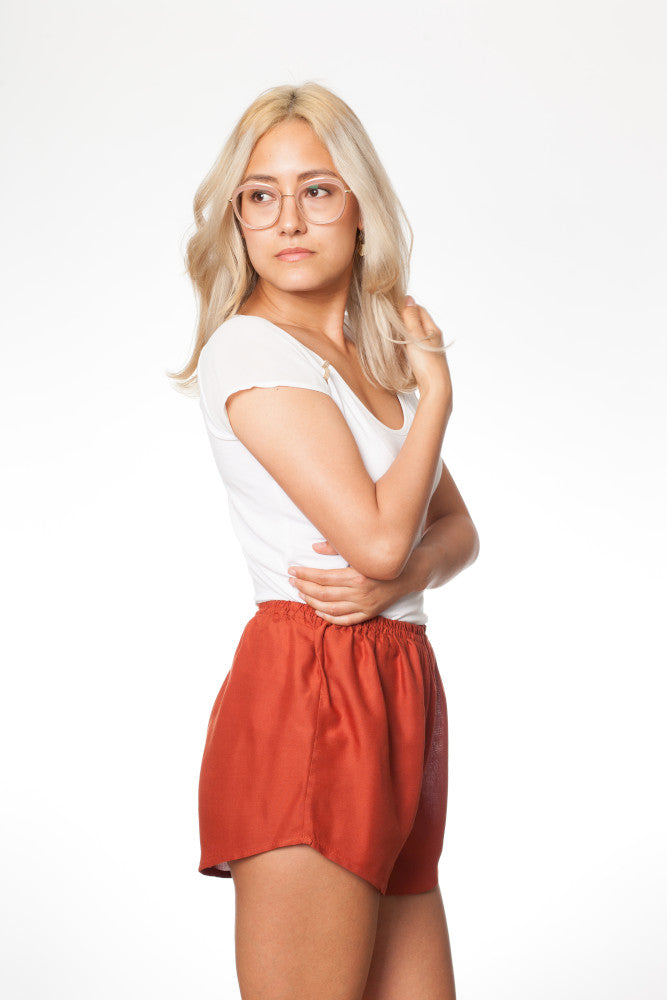 Frau in orangener Shorts von der Seite